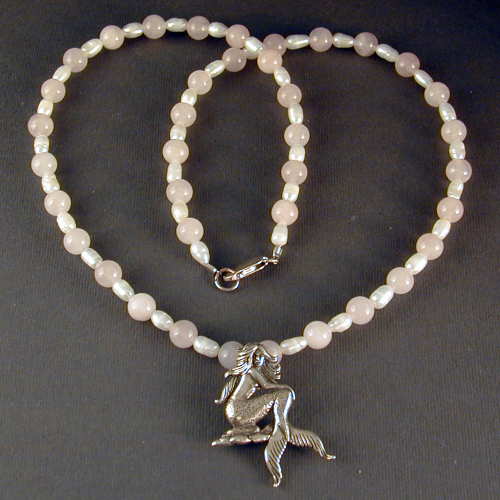 Sterling silver mermaid on a necklace of rose quartz and freshwater pearls.