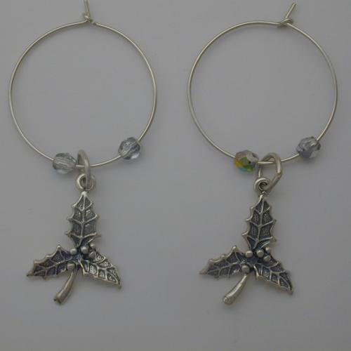 Sterling silver hoop with a sterling silver branch of holly by two clear Czech glass beads.