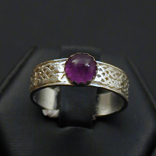 This simple knotwork band is adorned with an amethyst cabrochon.