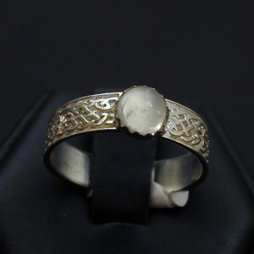 This simple knotwork band is adorned with an moonstone cabrochon.