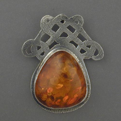 This lovely handmade pendent of cutwork silver and amber has 4 intertwined hearts. See if you can find them.