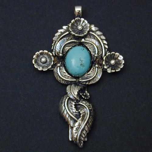This cross covered with leaves and flowers is set with a lovely turquoise cabochon.