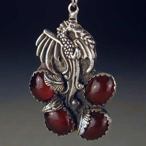 Flaming dragon rises out of the embers of 4 carnelian cabochon stones.