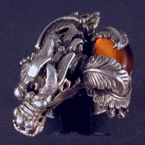 Have powerful dragon wraped around your finger with this large sterling silver ring.  The stone in the one of a kind piece is Amber.