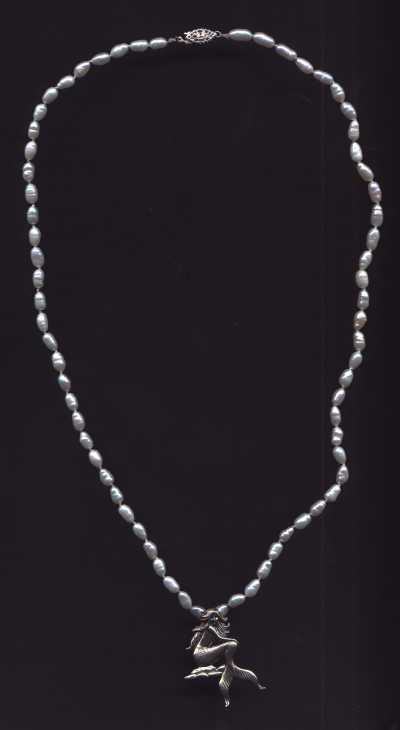 This is an 18 inch hand-knotted white fresh water pearl necklace. The pearls are hand-knotted on silk by Angelique Black. It has a sterling silver mermaid and clasp. Please allow 2 weeks for delivery.