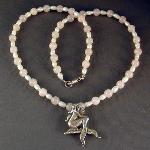 Sterling silver mermaid on a necklace of rose quartz and freshwater pearls.