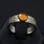 This simple knotwork band is adorned with an amber cabrochon.
