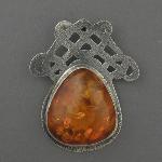 This lovely handmade pendent of cutwork silver and amber has 4 intertwined hearts. See if you can find them.