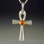 This 1 3/4 by 1 1/4 ankh has a lovely piece of amber set on it. This piece is also available in other cabochon stones.