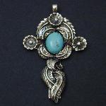 This cross covered with leaves and flowers is set with a lovely turquoise cabochon.