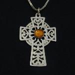 This lovely celtic cross holds an amber cabochon.