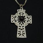 This lovely celtic cross holds an garnet cabochon.