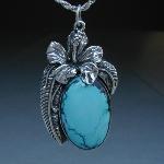 Imagine the blue tropical skies above lovely hibiscus bushes with this turquoise and sterling silver pendent. Take yourself on a mental vacation with this necklace.